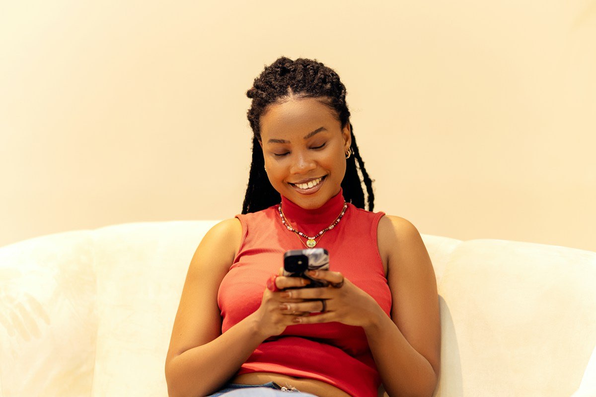 Nigerian resident using a mobile phone at home